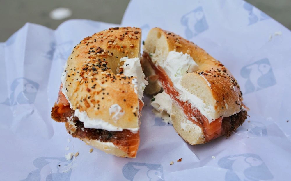 Bagel con queso crema y salmón ahumado sobre papel en una tienda del Lower East Side