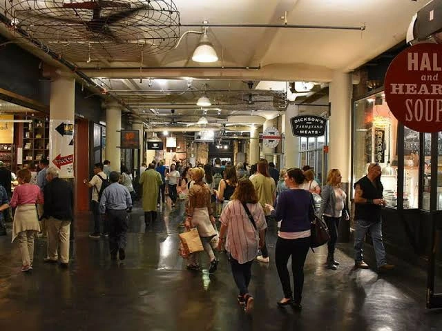 Pasillo de ladrillo del Chelsea Market con gente recorriendo puestos de comida