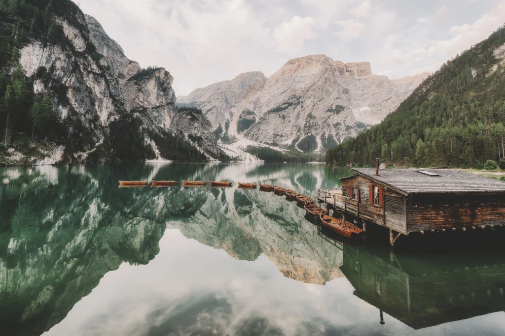 Lago di Braies con sus botes de madera y montañas de las Dolomitas reflejadas en el agua