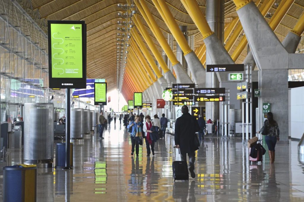 Viajeros con valijas en la zona de llegadas del aeropuerto de Madrid Barajas