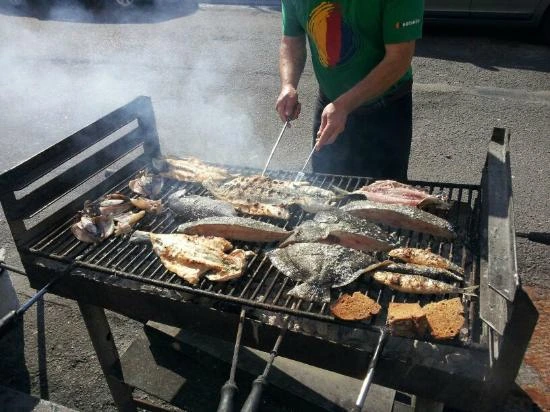 Parrilla callejera con pescado fresco frente a un restaurante de Matosinhos