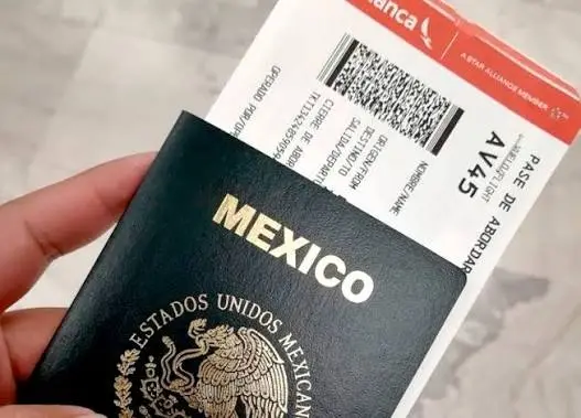 Pasaporte mexicano junto a un boleto de avión y una libreta sobre una mesa