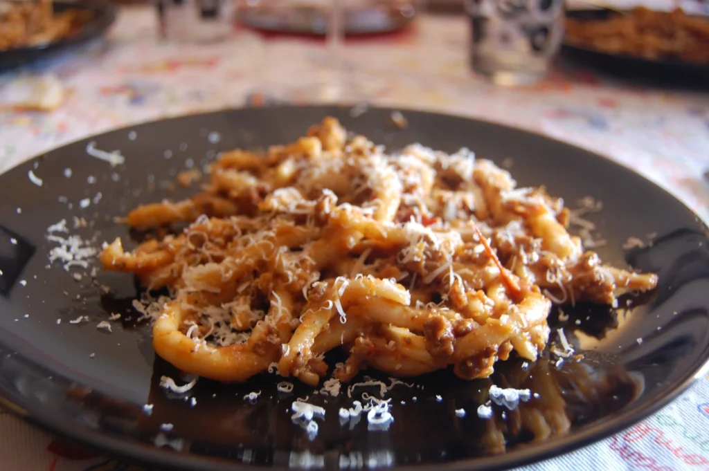 Plato de pici con ragú servido en una trattoria toscana