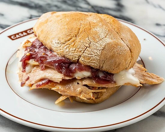Sándwich de pernil de cerdo con queso de la sierra en un mostrador de Oporto