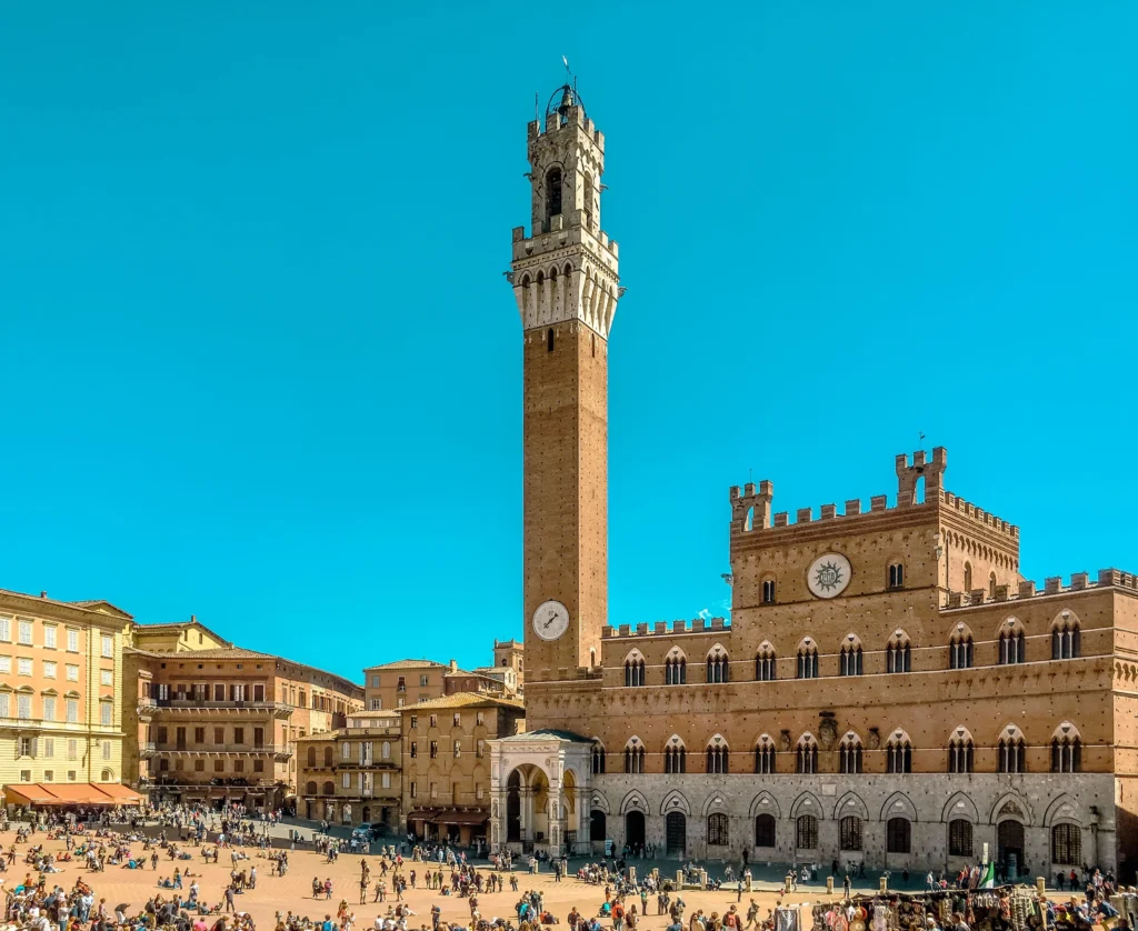 Piazza del Campo de Siena con el Palazzo Pubblico y la Torre del Mangia al atardecer