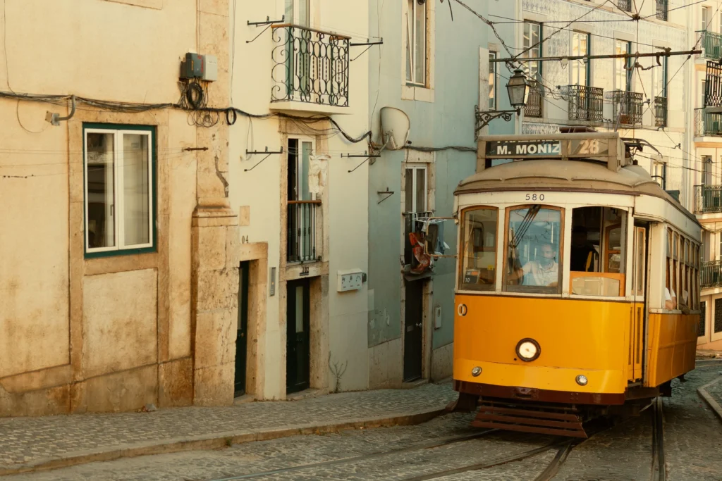 Tranvía amarillo subiendo por una calle angosta de Alfama en Lisboa