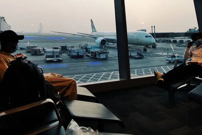 Viajera revisando su reserva de hotel y sus documentos antes de un vuelo a España