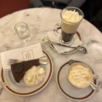 Mesa de mármol en un café tradicional de Viena con melange y porción de torta