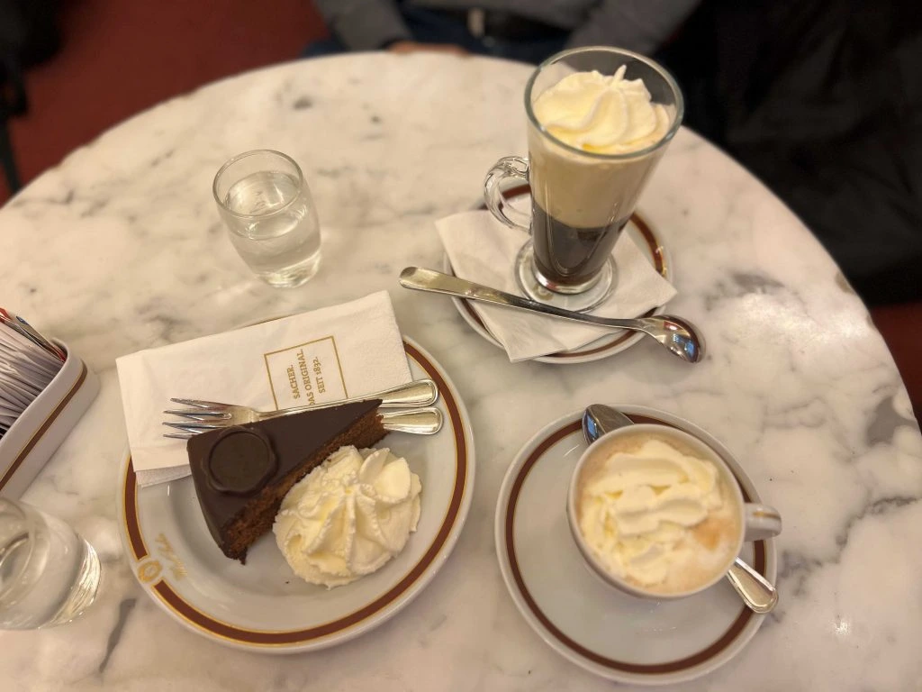 Mesa de mármol en un café tradicional de Viena con melange y porción de torta
